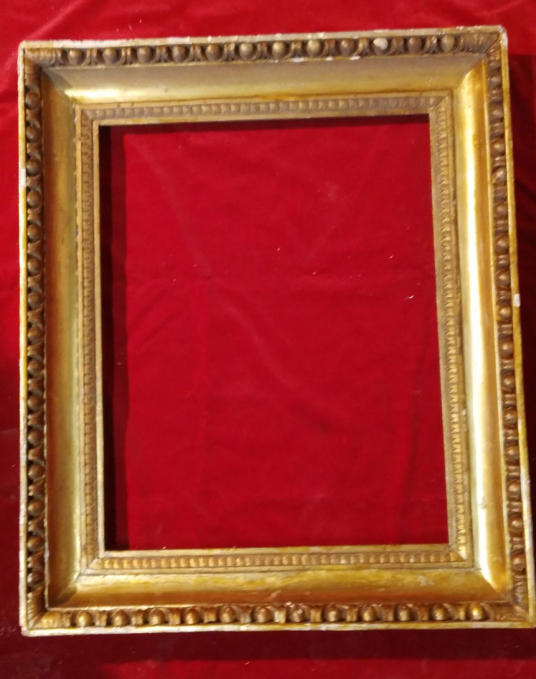 Cornice in legno dorato ed intagliato con motivo ad ovuli e fogliette d'acanto.Sagoma a gola Impero luce cm.49 x 63 I° 800